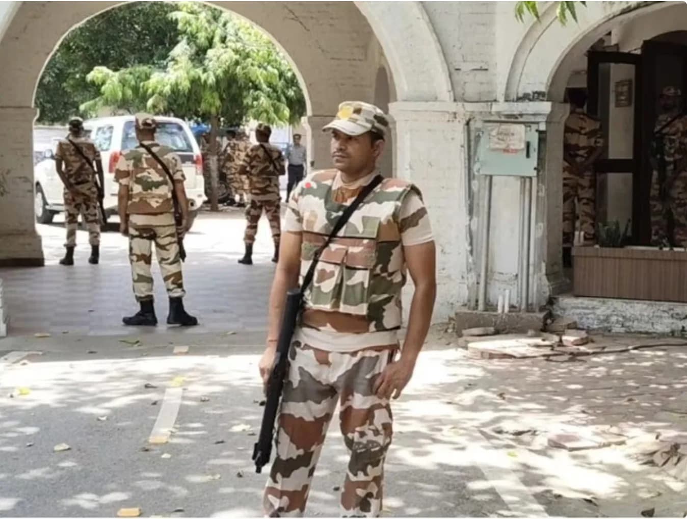 सशस्त्र सुरक्षाकर्मी इमारत के बाहर पहरा दे रहे हैं।
