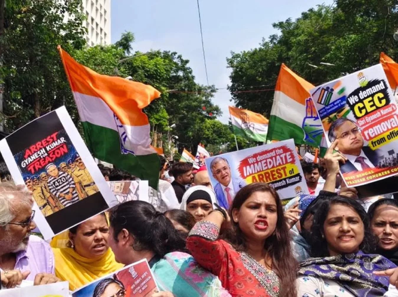 भारतीय झंडे लहराते हुए लोग ज्ञानेश कुमार की गिरफ्तारी की मांग कर रहे हैं।