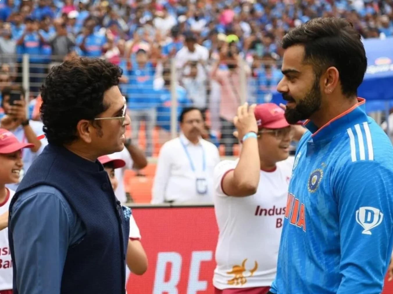 सचिन तेंदुलकर और विराट कोहली क्रिकेट मैदान पर बातचीत करते हुए।