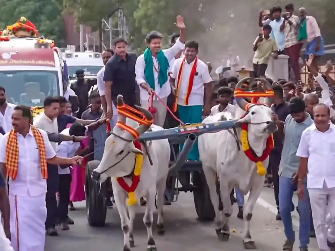 दो बैलगाड़ी में बैठे लोग, जिन्हें दो बैल खींच रहे हैं।