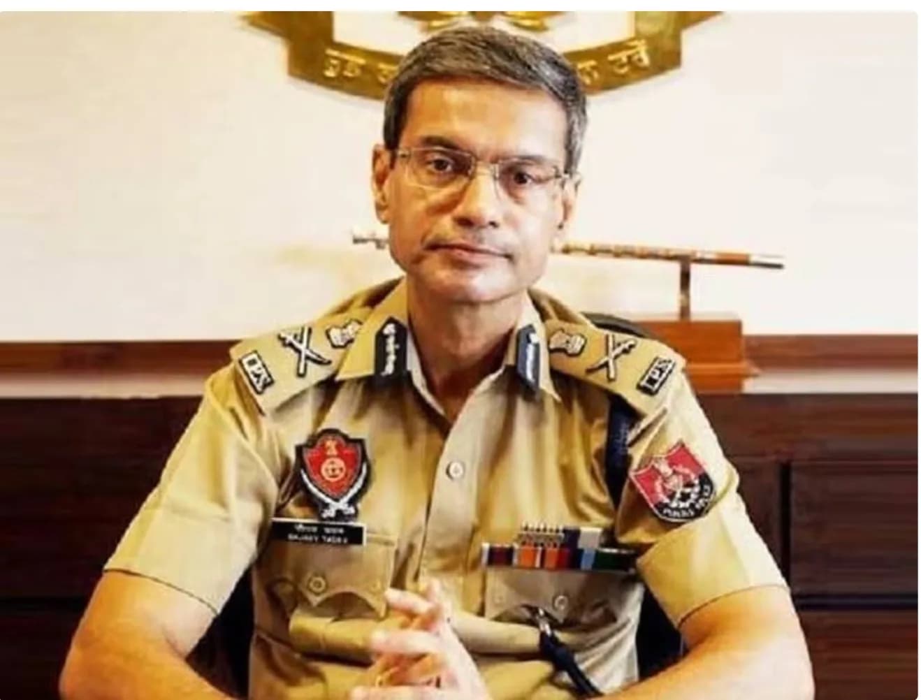 एक पुलिस अधिकारी अपनी वर्दी में बैठा है।