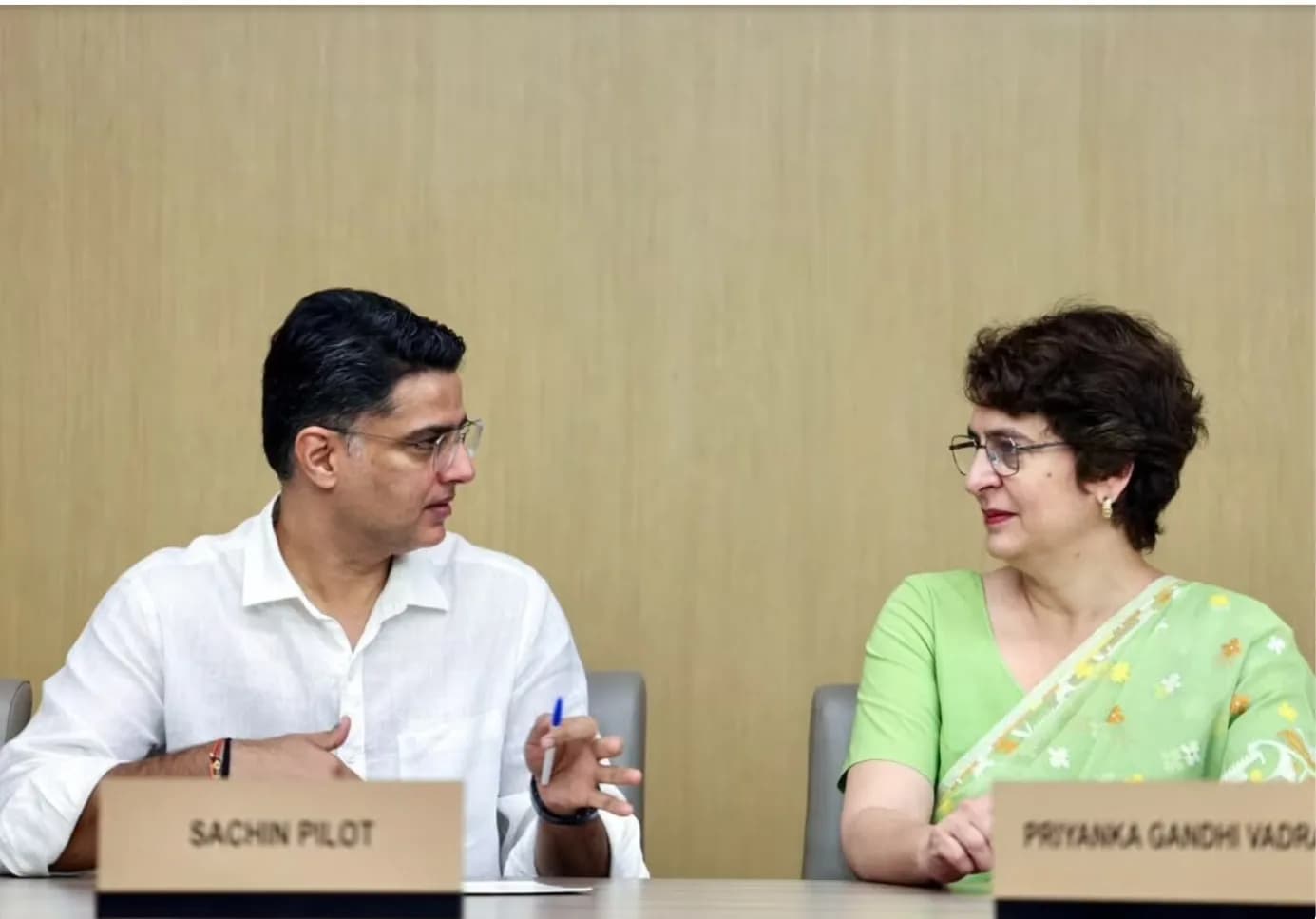 सचिन पायलट और प्रियंका गांधी वाड्रा एक मेज पर बैठे हुए हैं।