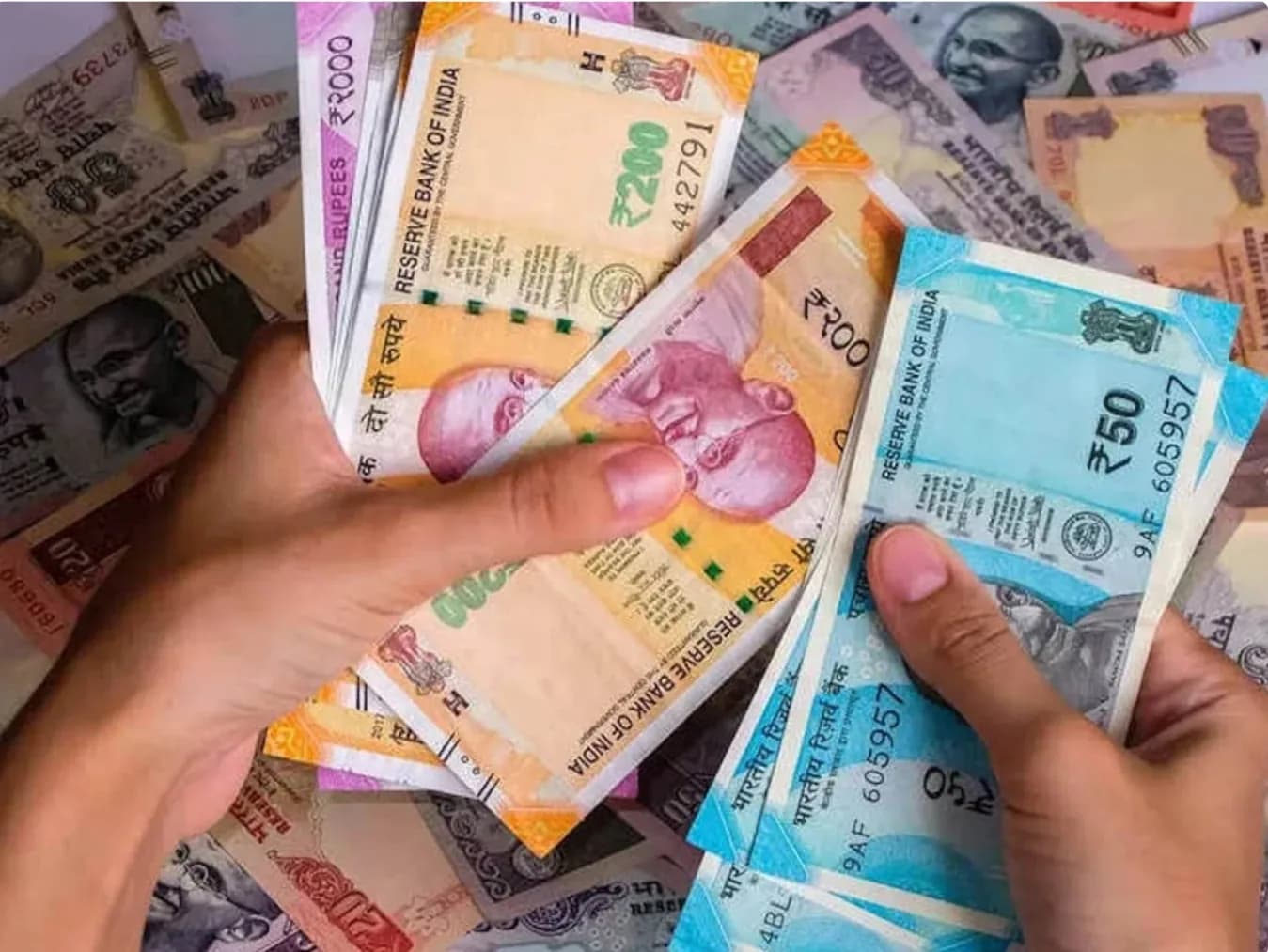 हाथों में भारतीय रुपये के नोट पकड़े हुए, पृष्ठभूमि में और नोट बिखरे हुए हैं।