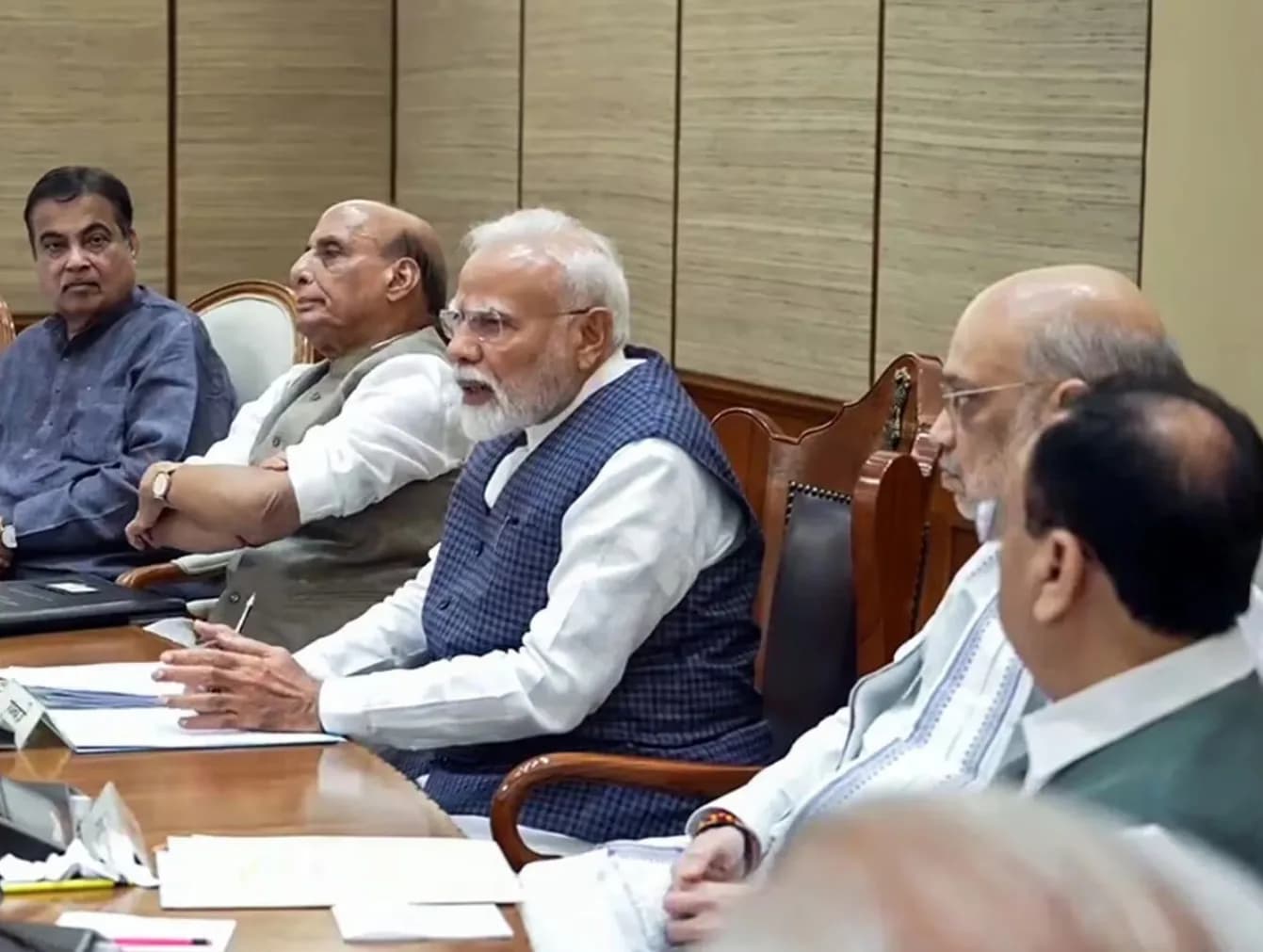 प्रधानमंत्री नरेंद्र मोदी एक बैठक में अन्य मंत्रियों के साथ मेज पर बैठे हैं।