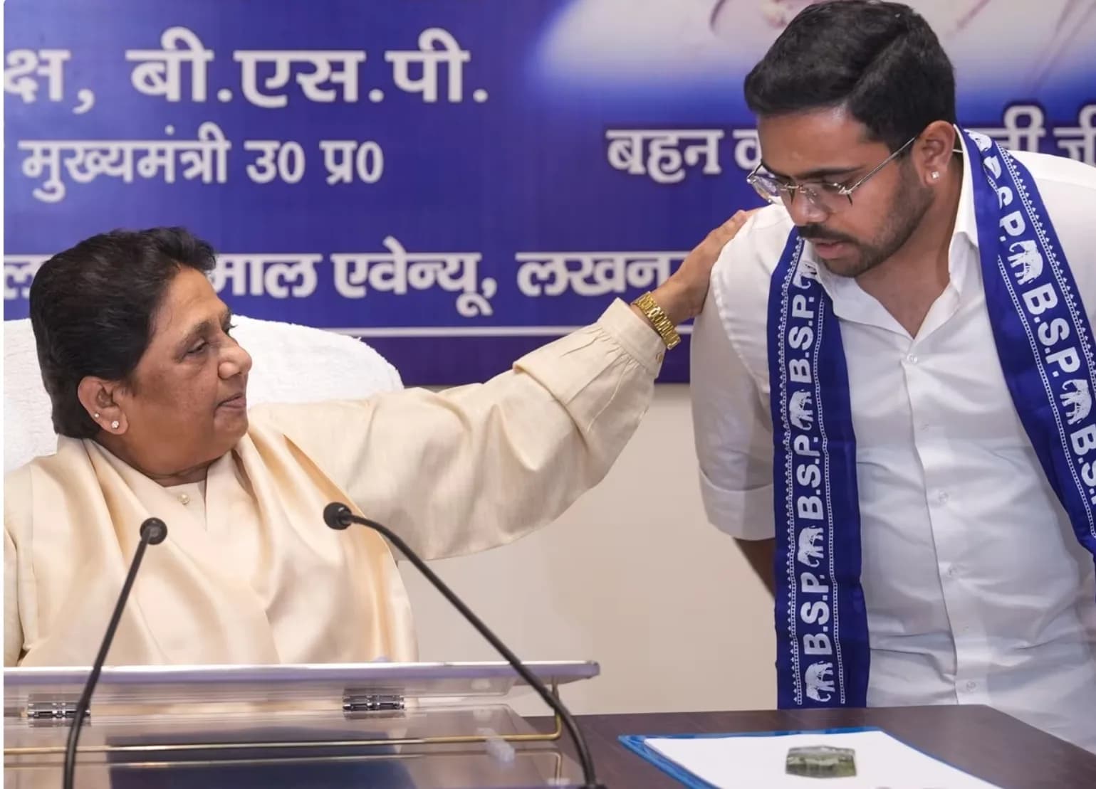 एक महिला एक पुरुष के कंधे पर हाथ रखती है।