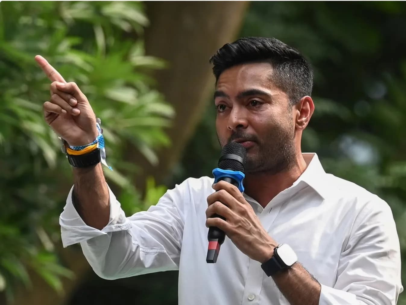 एक आदमी माइक्रोफ़ोन पकड़े हुए और उंगली उठा रहा है।